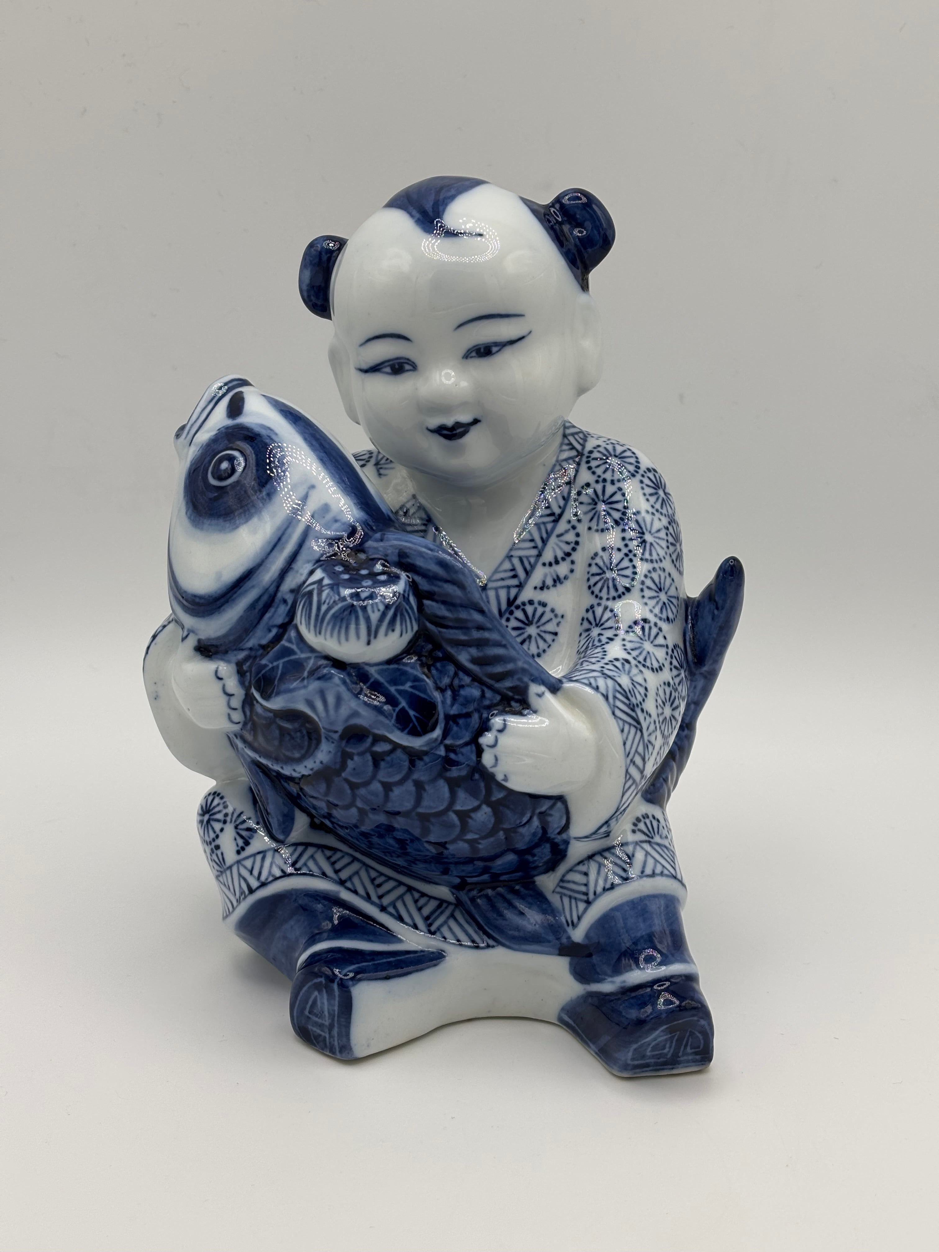 Statuette enfant au poisson en porcelaine