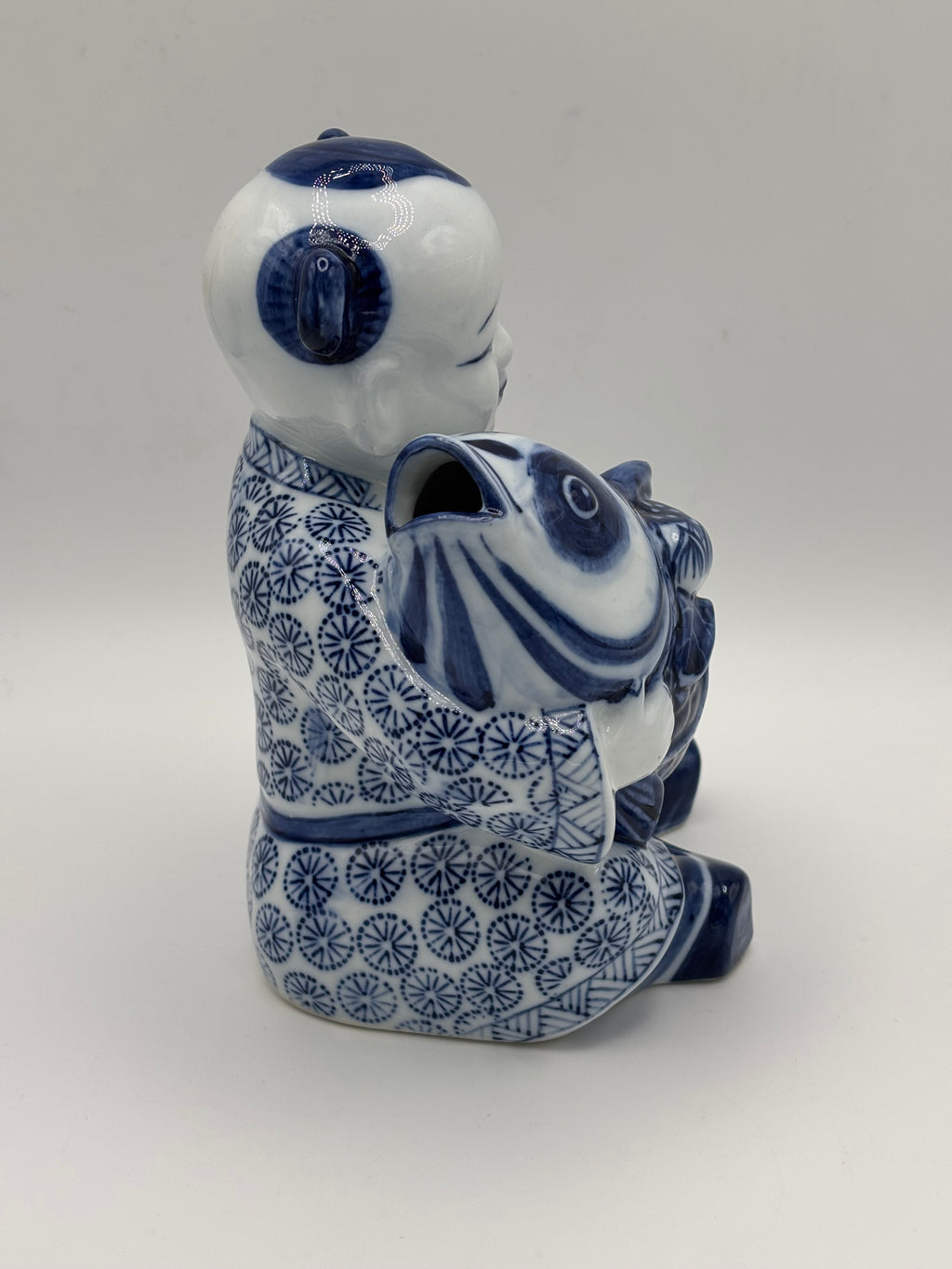 Statuette enfant au poisson en porcelaine